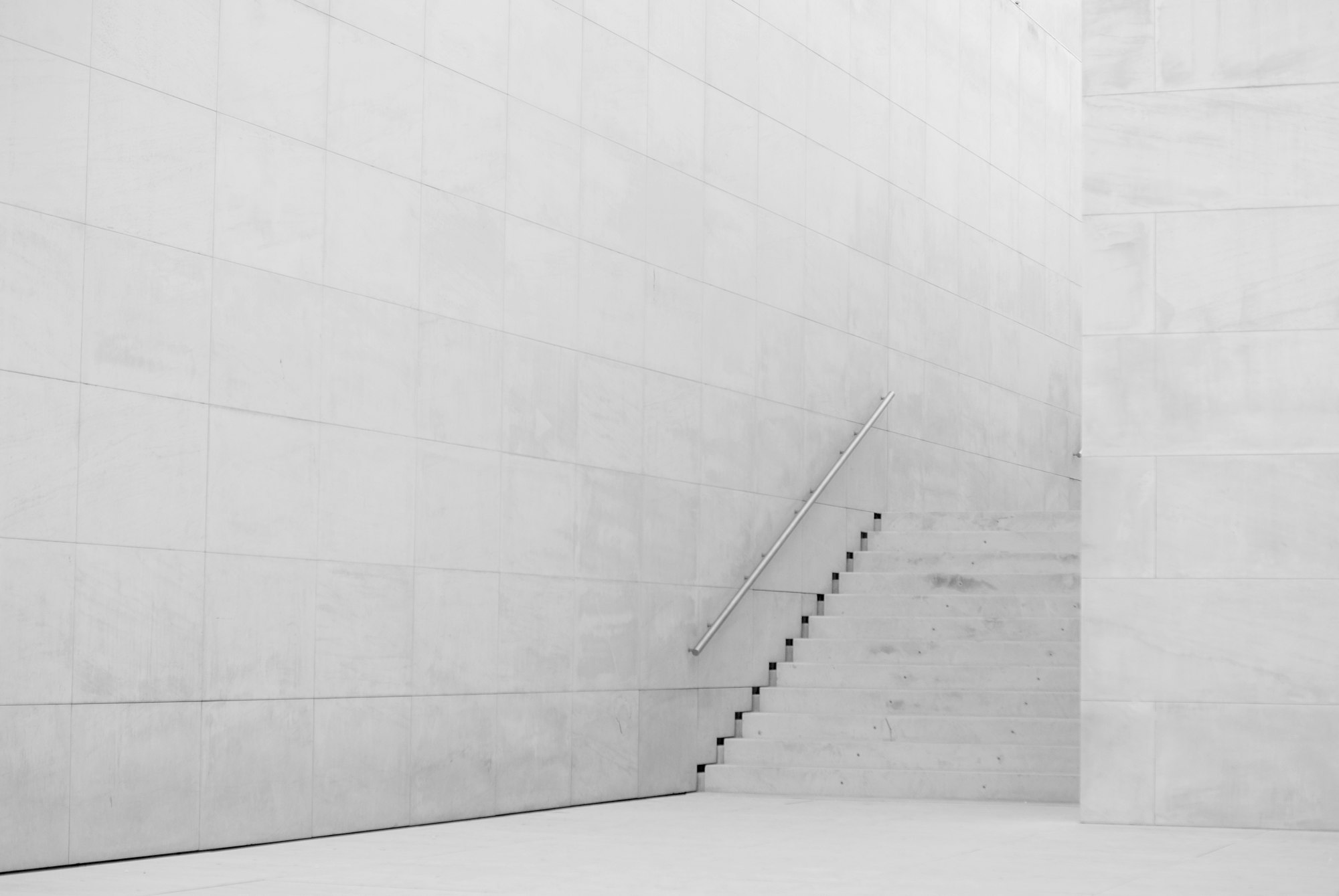 Architecture minimaliste en béton clair, escalier épuré
